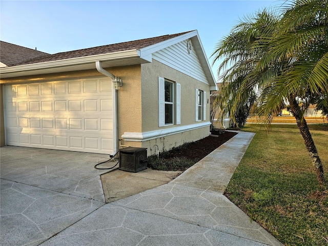 view of side of property featuring a yard and central AC