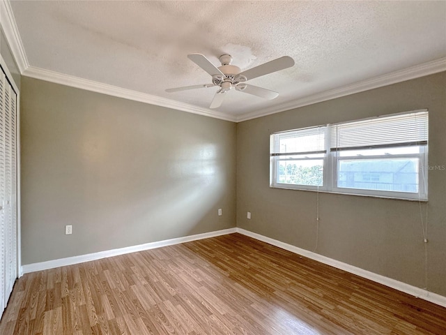 empty room with hardwood / wood-style floors, a textured ceiling, ceiling fan, and ornamental molding