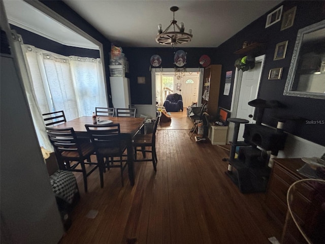 dining area with wood-type flooring and a chandelier