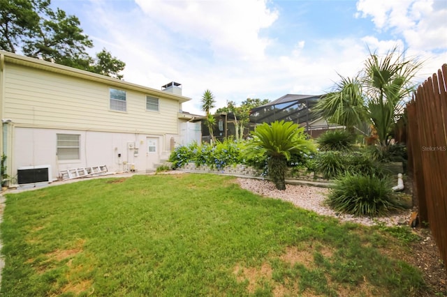 view of yard featuring central AC unit and a lanai