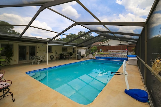 view of pool with a lanai, a patio area, and french doors