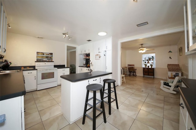 kitchen featuring electric range, ceiling fan, white cabinets, and sink