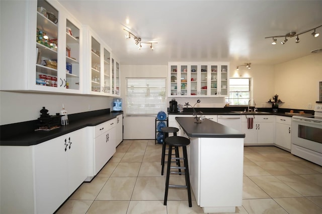 kitchen featuring a healthy amount of sunlight, white cabinetry, white electric range, and light tile patterned floors