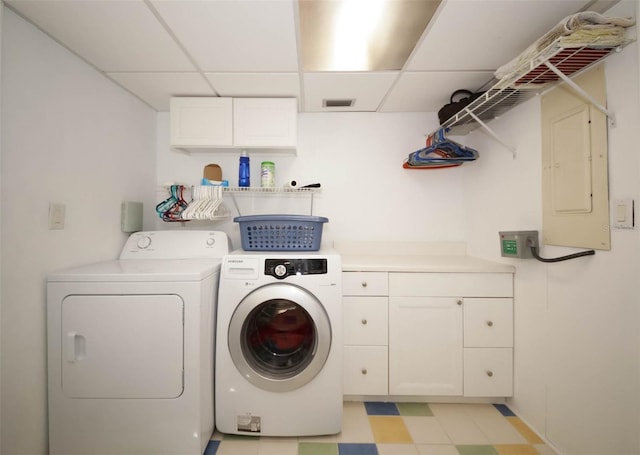 washroom featuring cabinets, separate washer and dryer, and electric panel