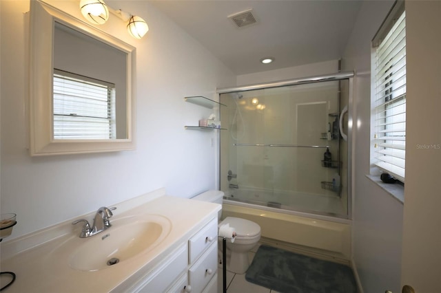 full bathroom with tile patterned floors, vanity, enclosed tub / shower combo, and toilet