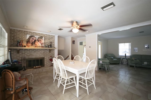 dining area featuring a fireplace, ceiling fan, and ornamental molding