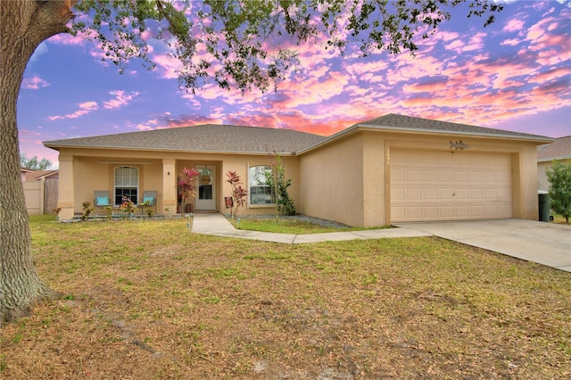 ranch-style home with a yard and a garage