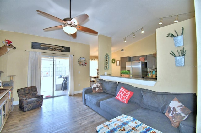 living room featuring ceiling fan, lofted ceiling, and light wood-type flooring