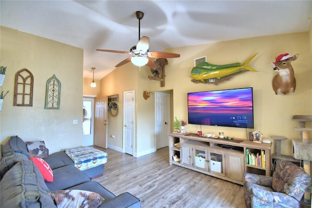 living room featuring ceiling fan, light hardwood / wood-style floors, and lofted ceiling