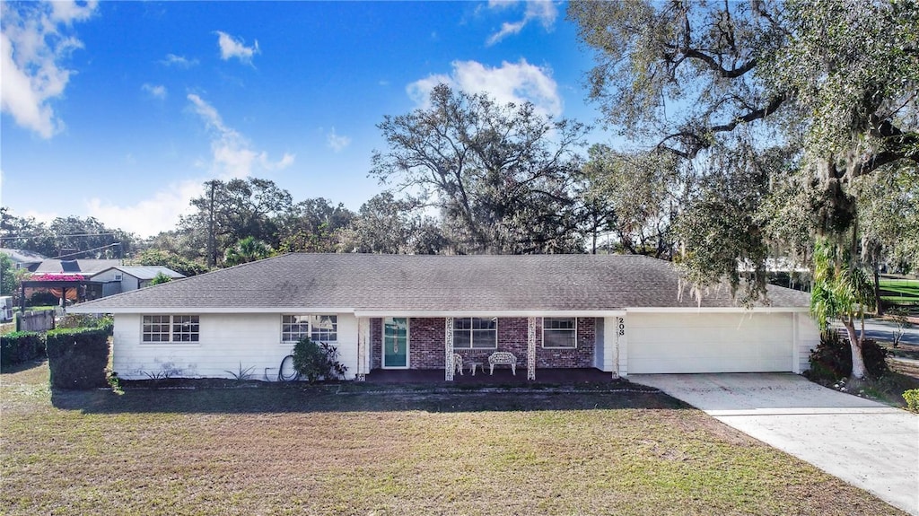 203 E Orange St, Davenport, FL 33837 - ranch-style home featuring a front yard and a garage