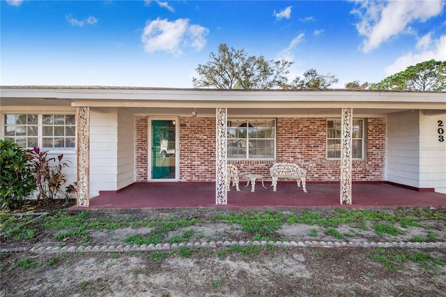 back of property featuring covered porch