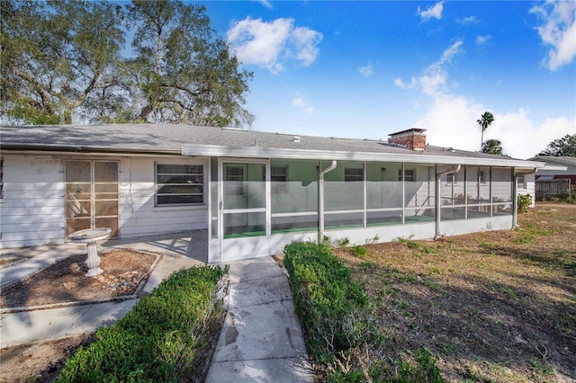 rear view of house featuring a sunroom