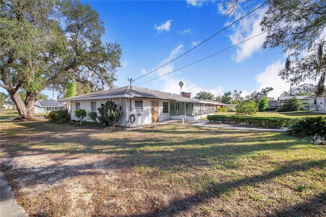 view of front of property with a sunroom and a front yard