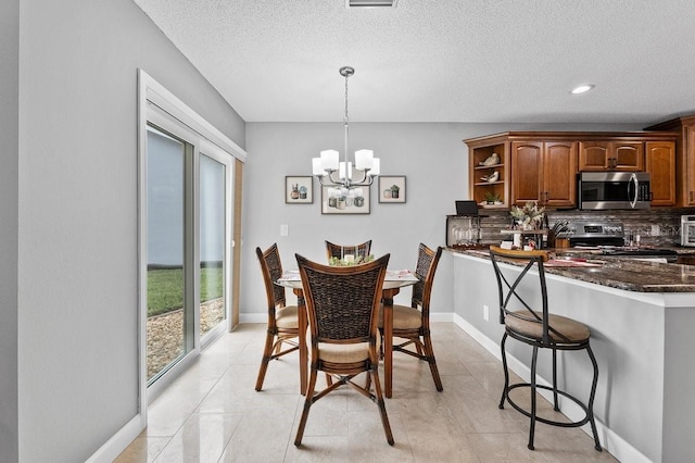 dining space with a textured ceiling and a notable chandelier