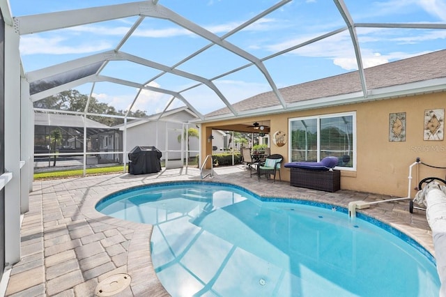 view of pool featuring glass enclosure, area for grilling, a patio area, and ceiling fan