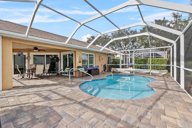 view of pool with ceiling fan, a patio area, and a lanai