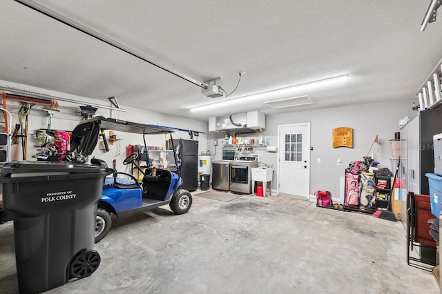 garage with washer and dryer, black fridge, sink, and a garage door opener