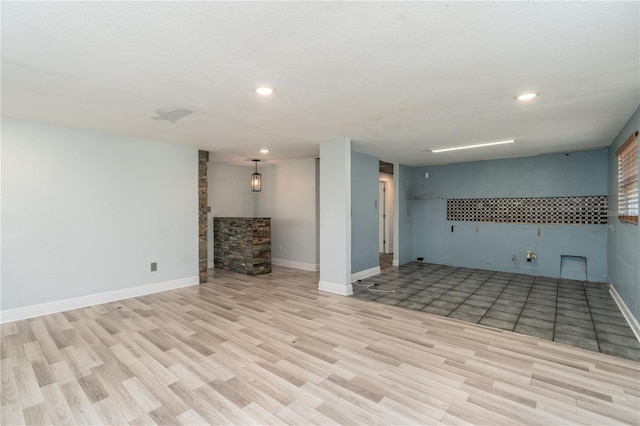 basement with a textured ceiling and light hardwood / wood-style floors