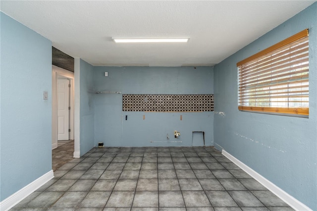 clothes washing area with hookup for a gas dryer and a textured ceiling