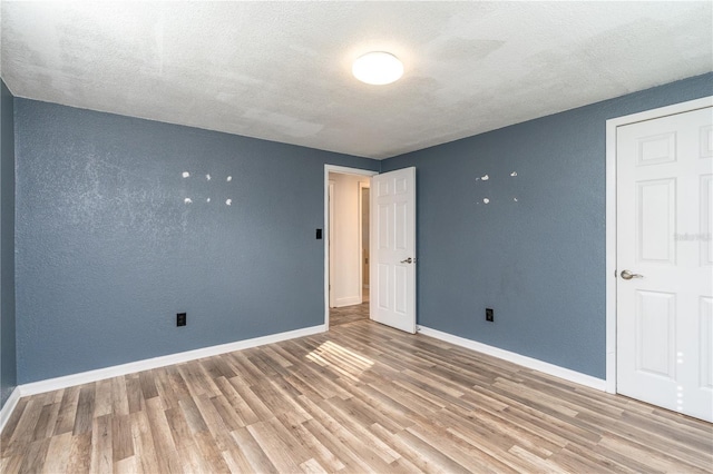 unfurnished bedroom with hardwood / wood-style floors and a textured ceiling