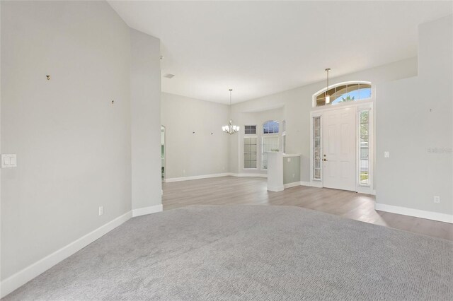 carpeted entryway with a chandelier