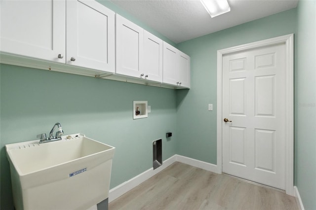 clothes washing area with cabinets, washer hookup, light wood-type flooring, hookup for an electric dryer, and sink