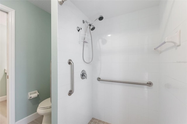 bathroom featuring tiled shower and toilet