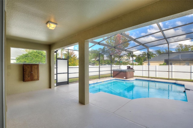 view of pool featuring a lanai, a patio area, and a hot tub