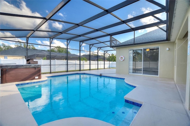 view of pool featuring glass enclosure, a patio area, and a hot tub