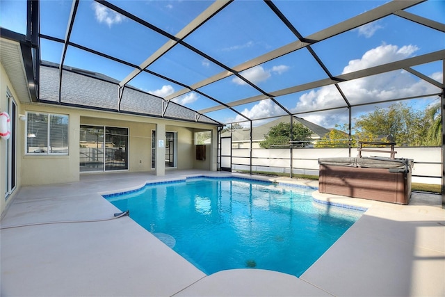 view of swimming pool with a patio, glass enclosure, and a hot tub