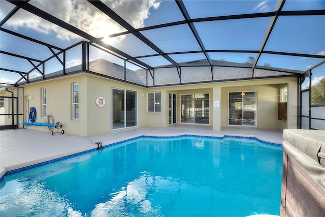 view of swimming pool featuring glass enclosure and a patio area