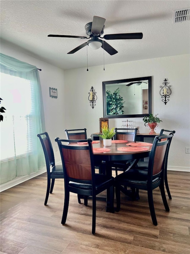 dining area featuring a textured ceiling, hardwood / wood-style flooring, and ceiling fan