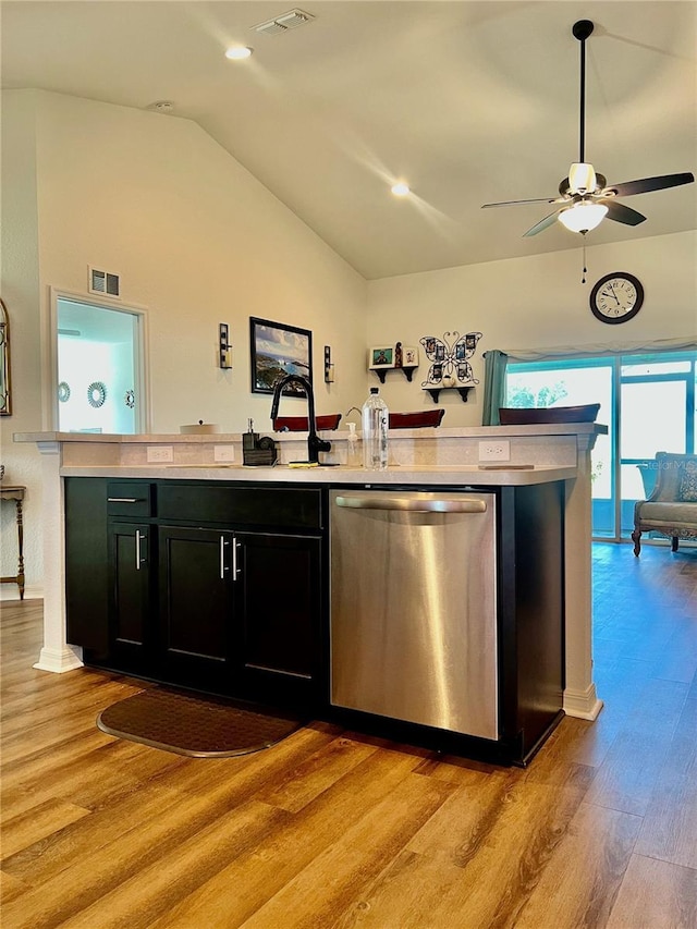 bar featuring stainless steel dishwasher, vaulted ceiling, ceiling fan, sink, and light hardwood / wood-style floors