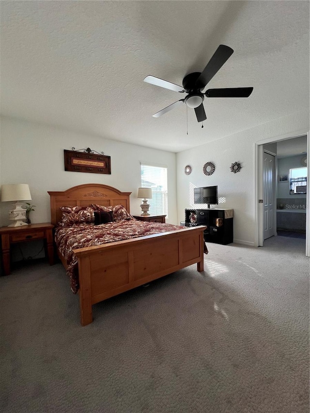 carpeted bedroom with ceiling fan and a textured ceiling