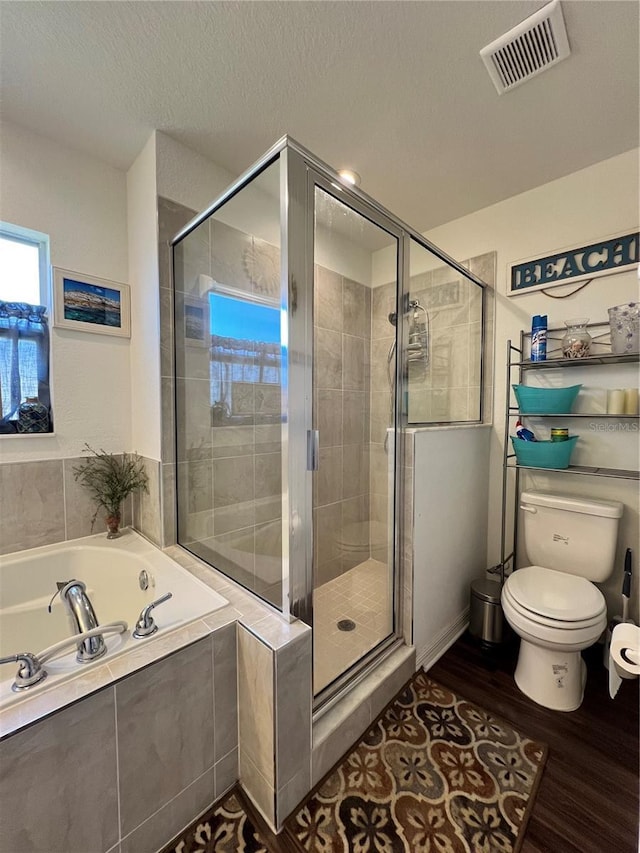 bathroom with hardwood / wood-style floors, a textured ceiling, toilet, and independent shower and bath