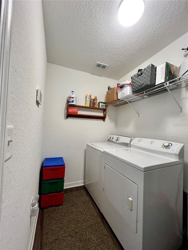 laundry area with a textured ceiling and separate washer and dryer