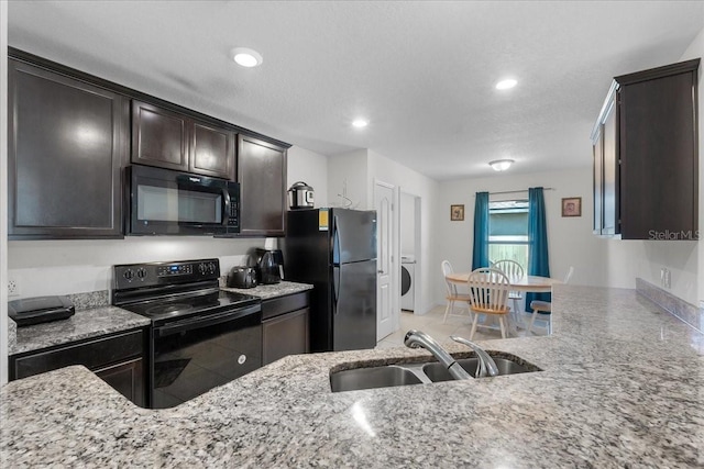 kitchen with light stone counters, dark brown cabinets, a textured ceiling, sink, and black appliances