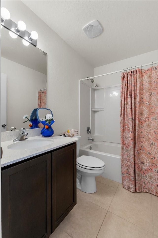 full bathroom featuring shower / bath combo, tile patterned flooring, vanity, a textured ceiling, and toilet