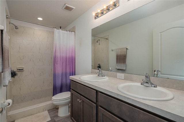 bathroom featuring hardwood / wood-style floors, vanity, toilet, and curtained shower