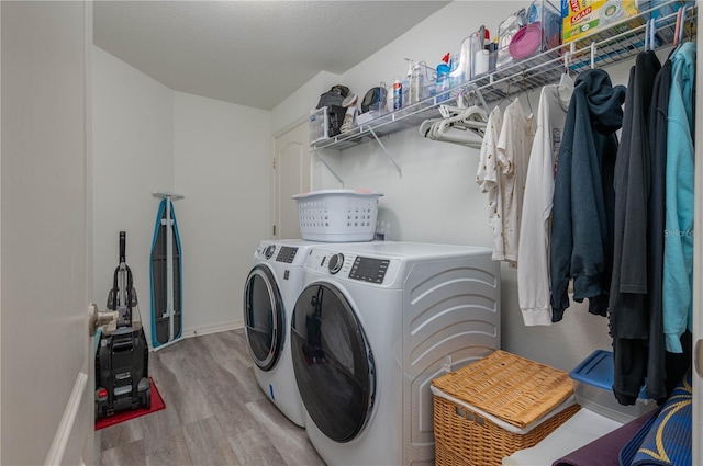 washroom with separate washer and dryer and light hardwood / wood-style flooring