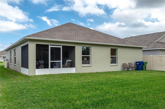 rear view of property with a yard and a sunroom