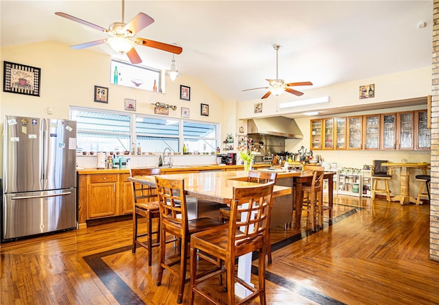 dining room featuring ceiling fan, lofted ceiling, sink, and dark wood-type flooring