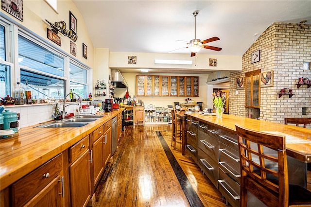 kitchen featuring dark hardwood / wood-style flooring, sink, brick wall, and wood counters