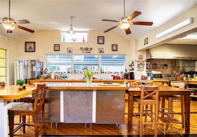 kitchen featuring wood counters, appliances with stainless steel finishes, ceiling fan, and lofted ceiling