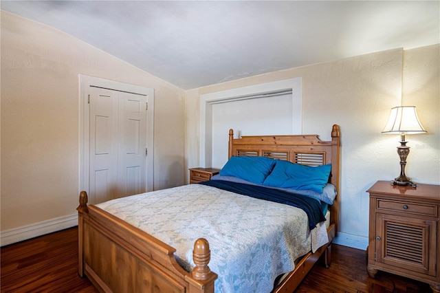 bedroom with dark hardwood / wood-style floors, vaulted ceiling, and a closet