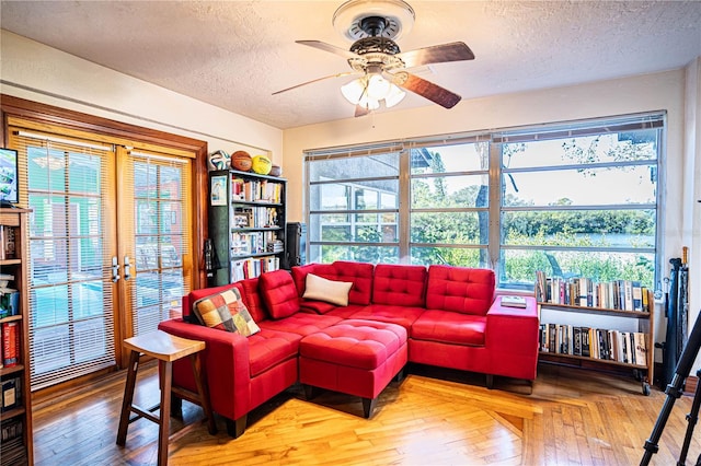 living room featuring ceiling fan, plenty of natural light, and a textured ceiling