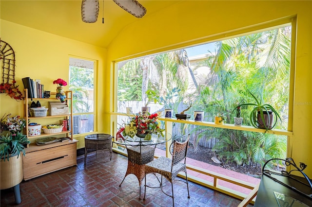 sunroom / solarium featuring a wealth of natural light, ceiling fan, and lofted ceiling