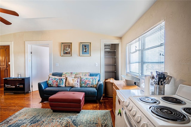 living room with ceiling fan, dark wood-type flooring, and vaulted ceiling