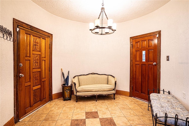 tiled foyer entrance featuring a textured ceiling and an inviting chandelier