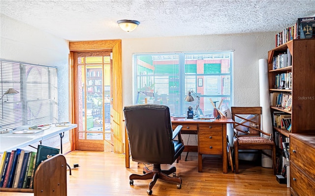 home office featuring a textured ceiling and light hardwood / wood-style flooring